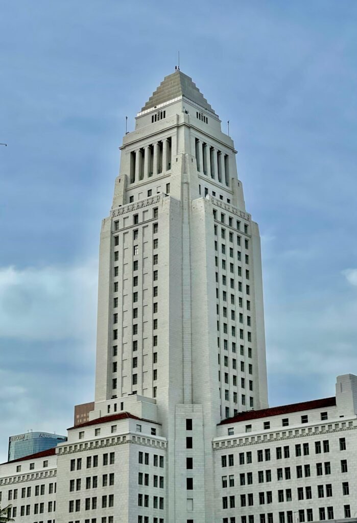 The landmark Los Angeles City Hall building on a clear day, showcasing its art deco architecture.
